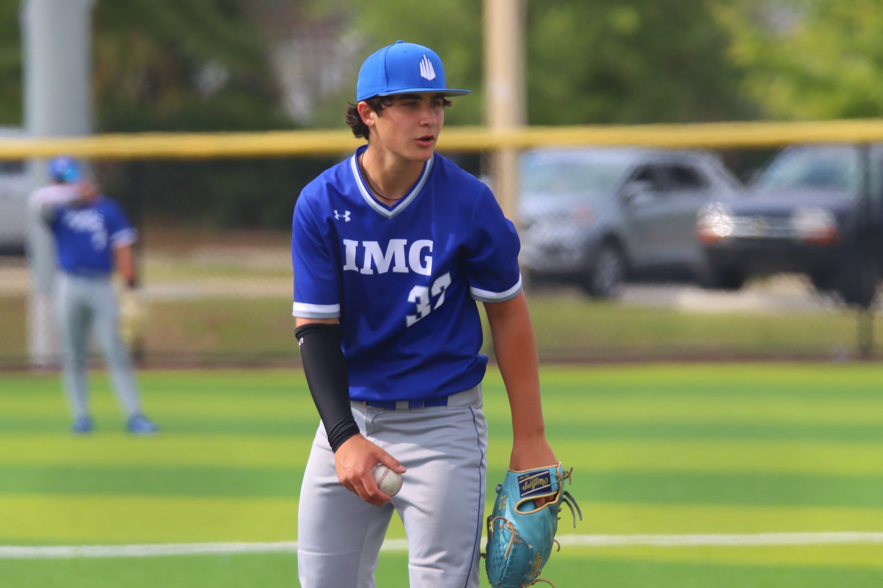 Pitcher on the mound, ball in hand, looking in