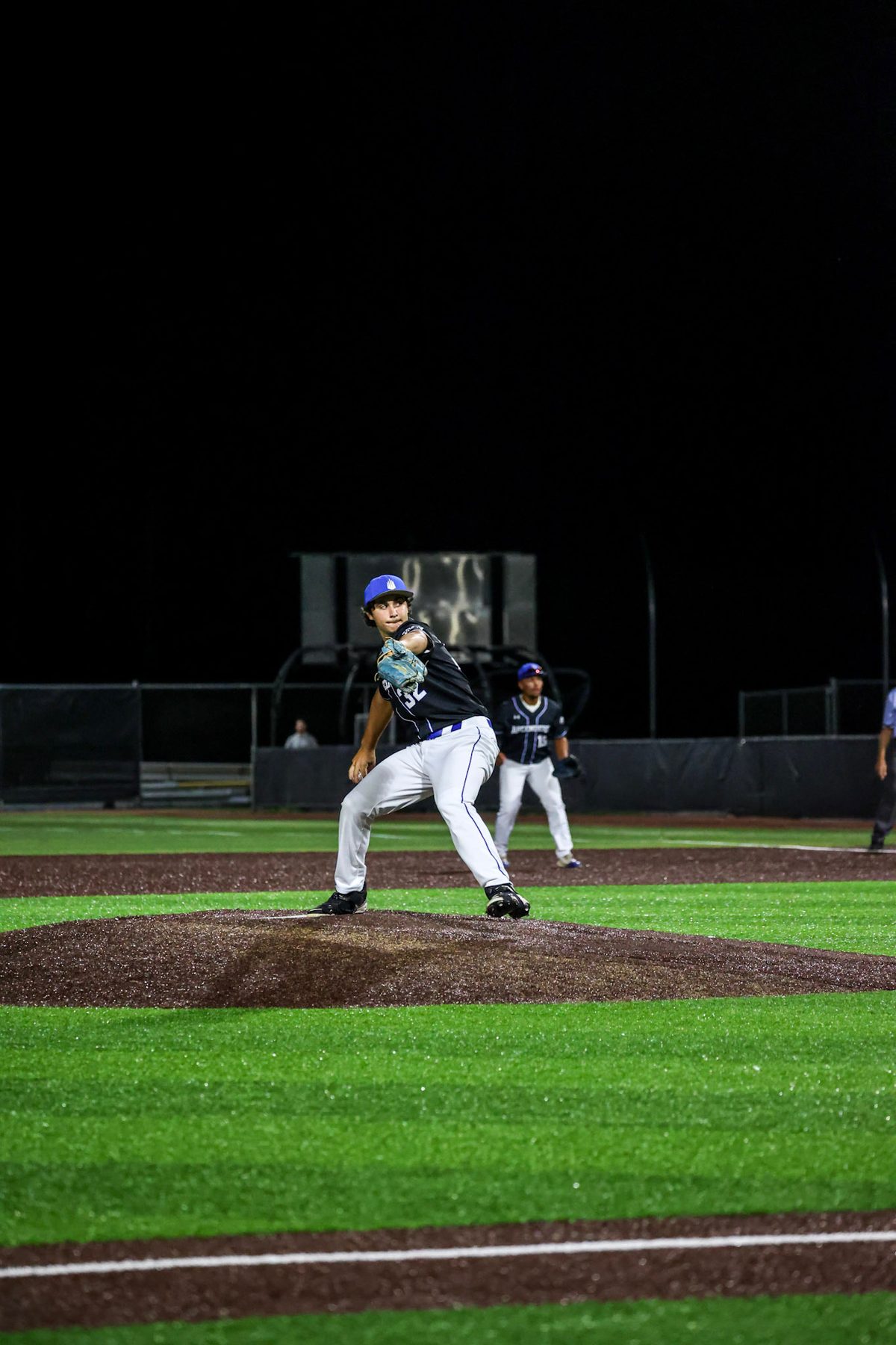 Pitcher in his delivery during a night game